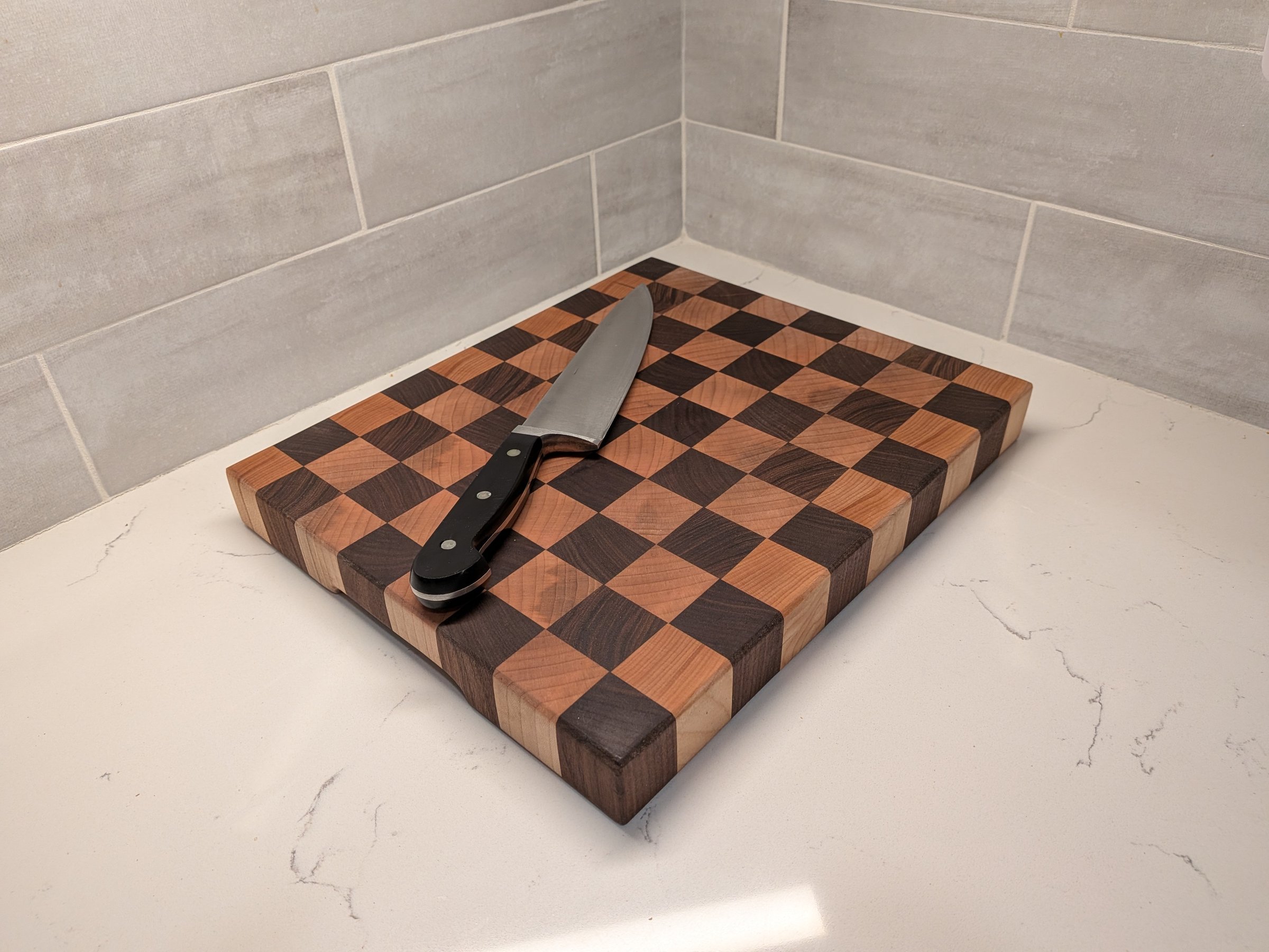 End-grain checkerboard cutting board with a chef's knife